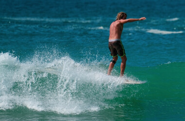 Surfer on a long board at Hiriketiya Beach, Sri Lanka