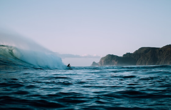 Surfer on a wave at Piha beach, New Zealand