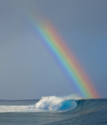 Teahupo'o wave under a rainbow