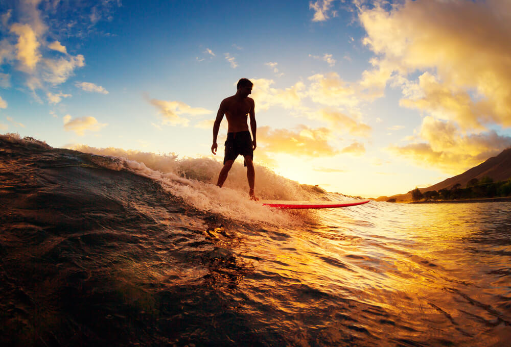 A-young-man-surfing-at-sunset