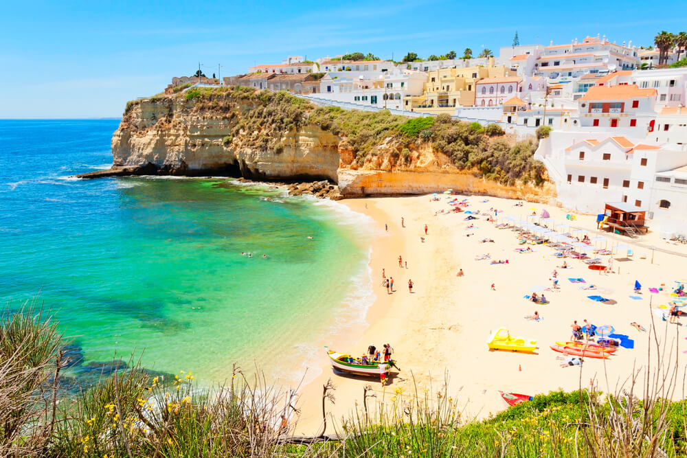 Beautiful beach of Carvoeiro (Algarve) on a summer sunny day, with some beachgoers on the sand