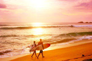 Surfers-walking-along-beach