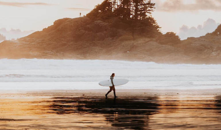 A surfer walking on the beach 