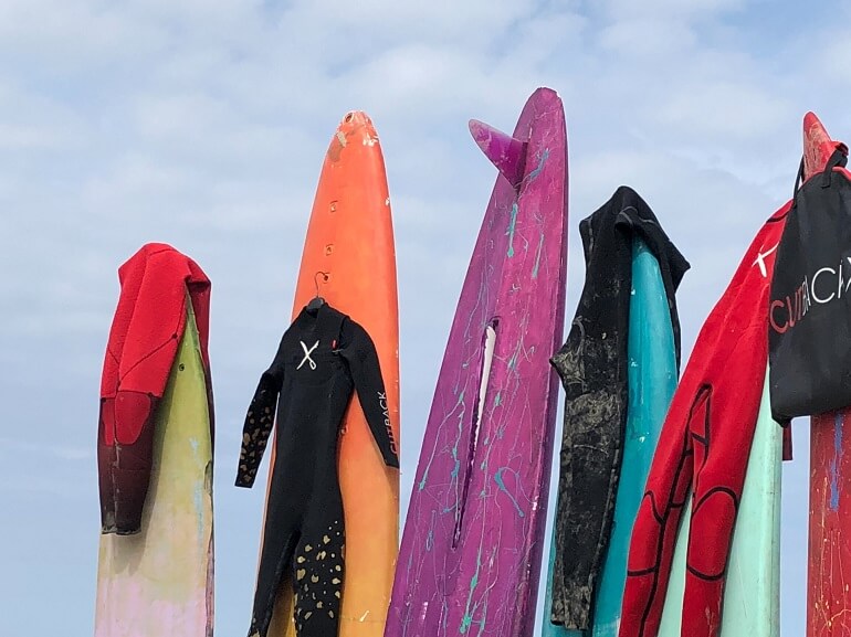 Wetsuits drying on top of surf boards