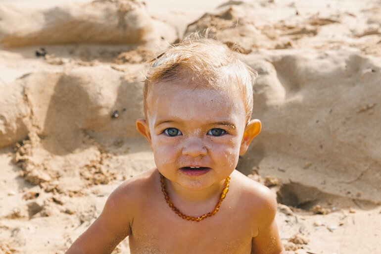 Little baby on the beach with sunscreen on his face