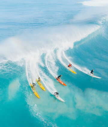 Long boarders catching a wave in Oahu, Hawaii