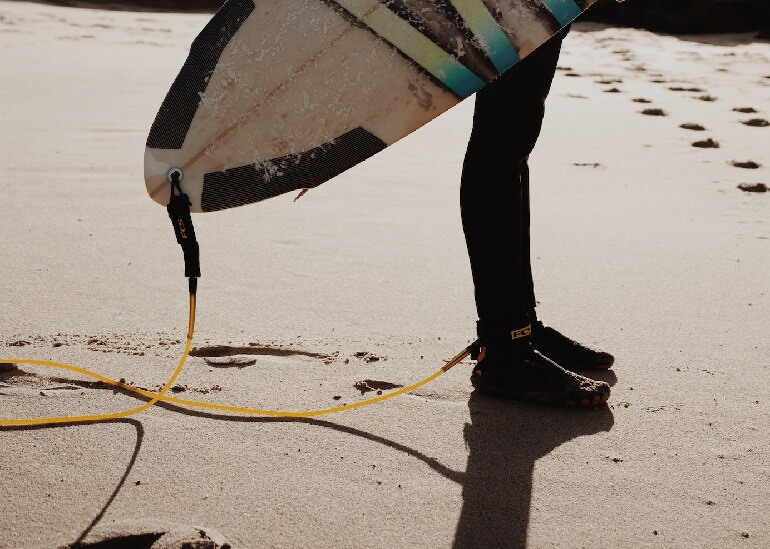 Surf leash attached to the board and to the foot of the surfer