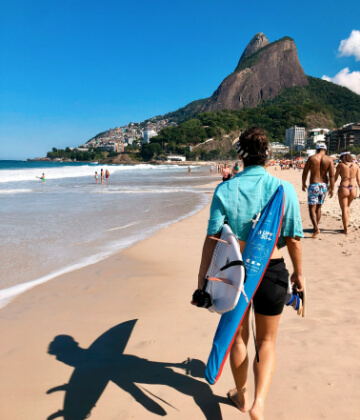 Surfer carrying a board at Copacabana beach, Brazil