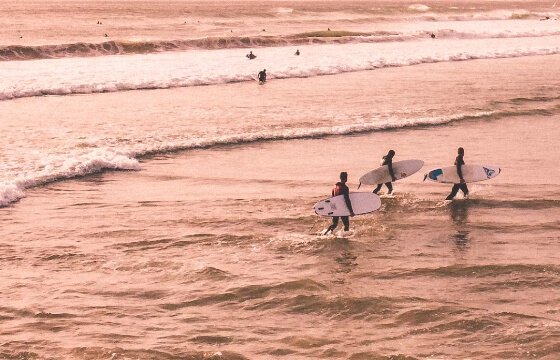 Surfers walking out of the beach at Montañita, Ecuador