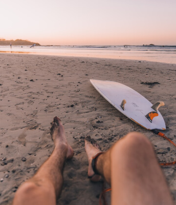 Surfer relaxing at the beach in Tamarindo, Costa Rica