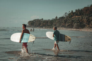 Surfers going into the water at Punta Arenas, Costa Rica