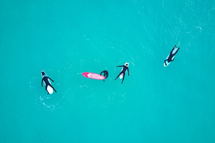 Surfers lying on top of their surf boards