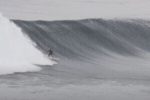 Surfer riding a big wave at Uluwatu, Bali