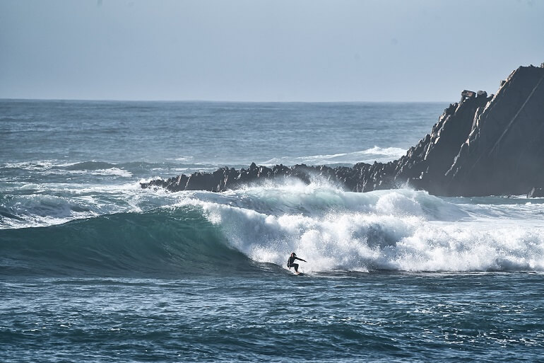 Surfer on a big wave at kanguru point in Arrifana