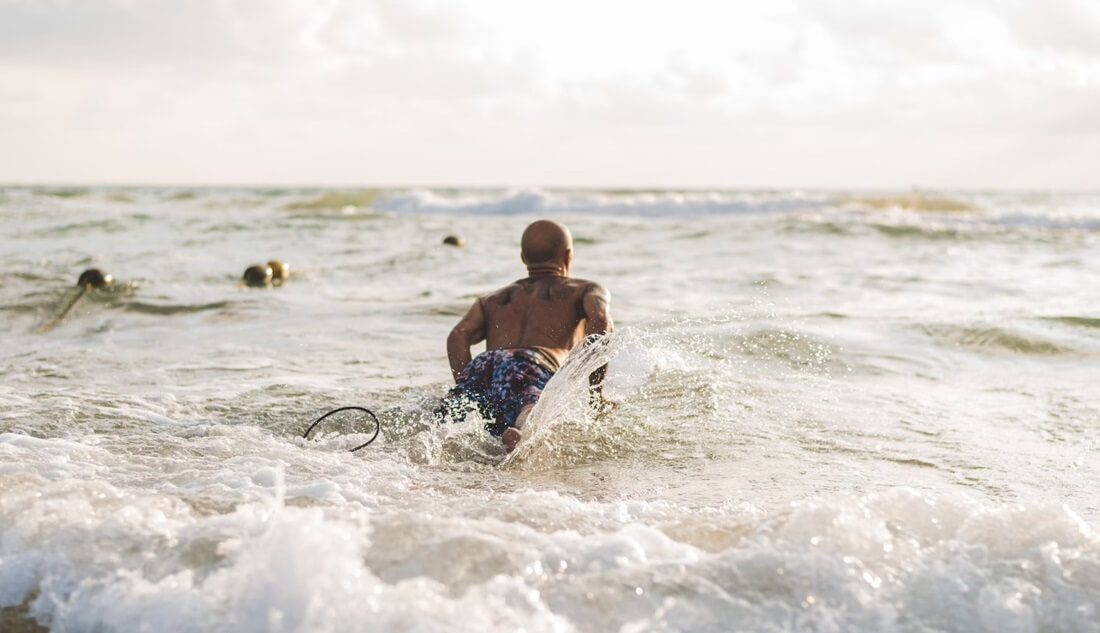 bald man surfing