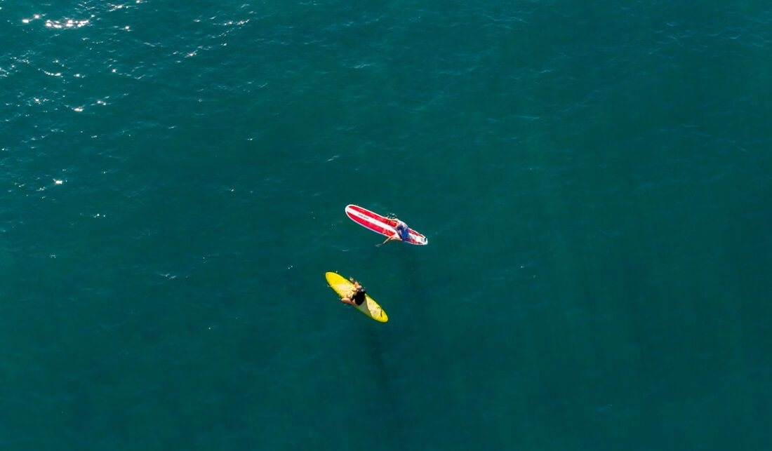 couple surfing in the sea