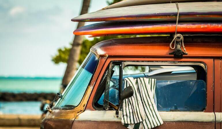 An old car loaded with surfboards 