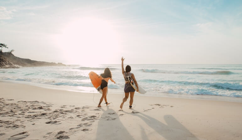 Two friends going for a surf 