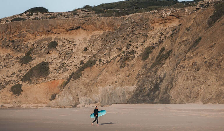 Surfer alone on the beach in Portugal 