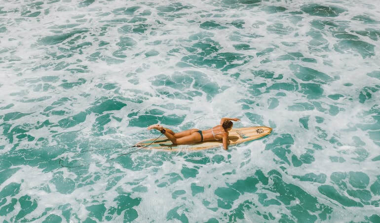 Surfer girl paddling 