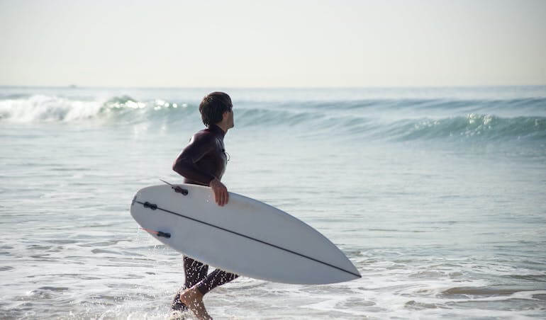 Surfer entering the ocean 