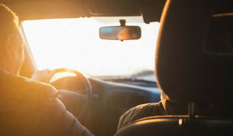 A couple of surfers in a car 