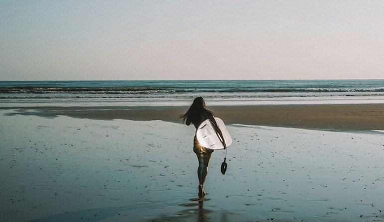 A surfer girl about to go surfing 